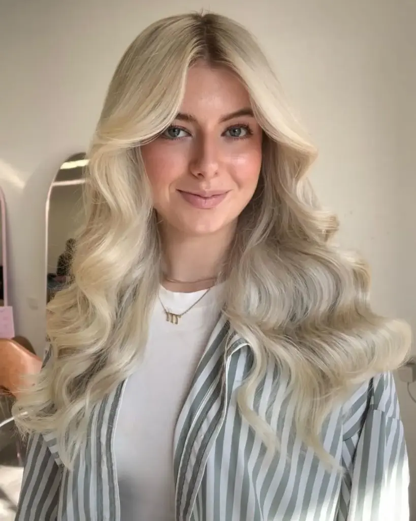 Butterfly frizura s kraćim slojevima oko lica i dužim pramenovima straga koja ublažava kutove kvadratnog lica