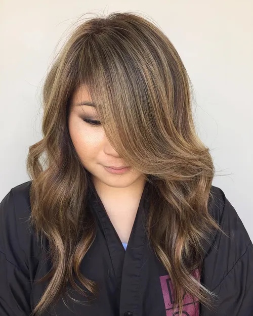 Dugi slojevi s pramenovima i stranim razdjeljkom koji izdužuju okruglo lice