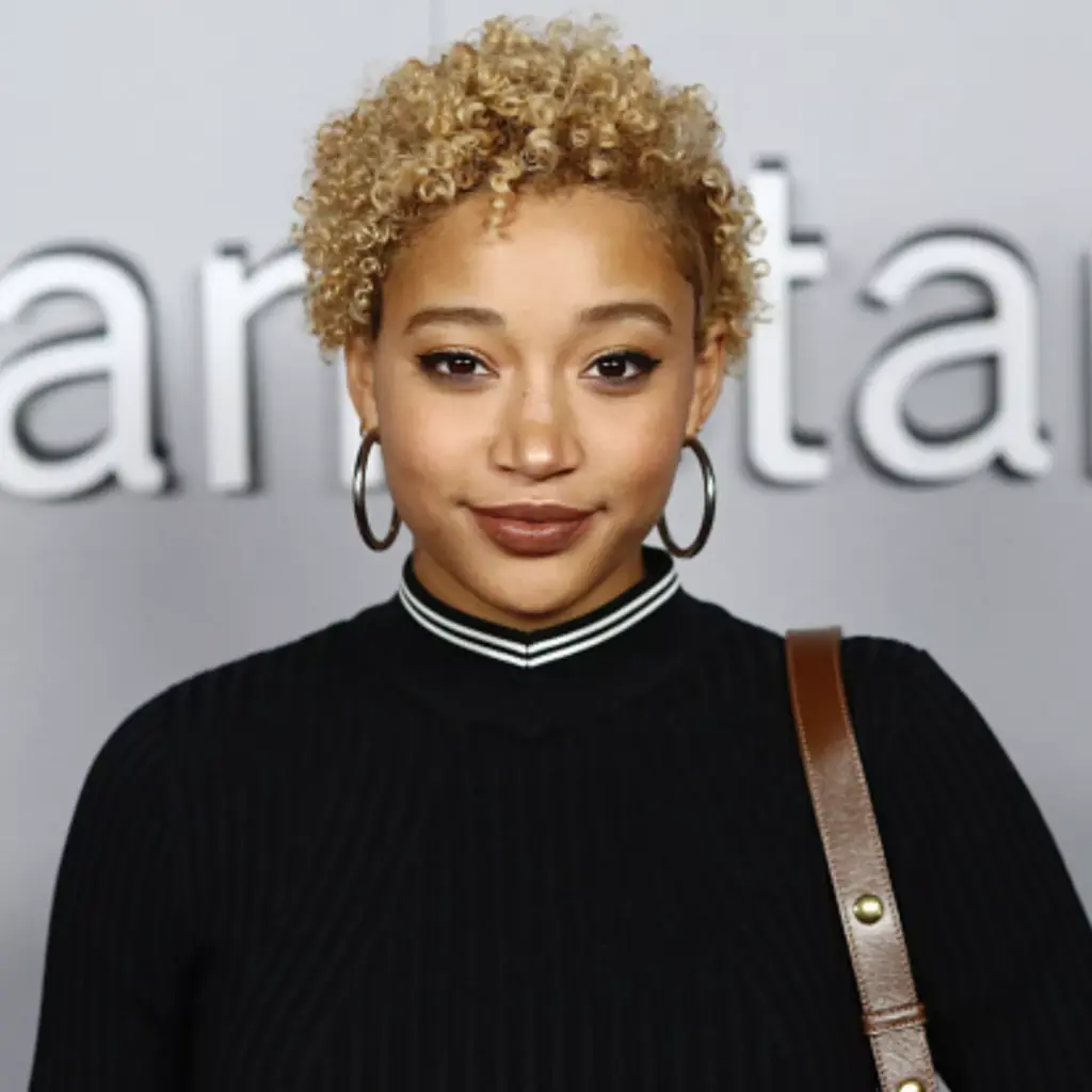 Kovrčavi pixie s mekim kovrčama koje dodaju širinu uz bradu i naglašavaju sklad srcolikog lica