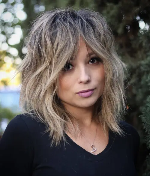 Razbarušeni wolf cut sa slojevima koji uravnotežuju proporcije dijamantnog lica