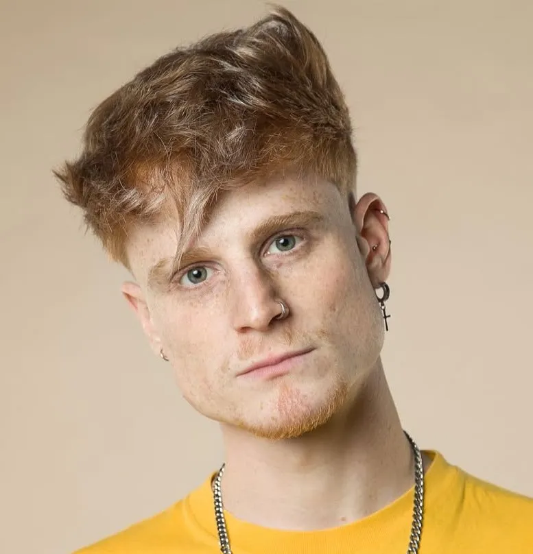 Asimetrična muška frizura koja razbija stroge linije i vizualno skraćuje pravokutno lice.