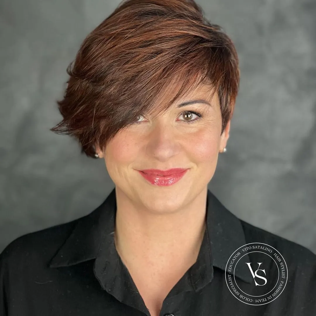 Asimetrični slojeviti pixie bob s mekanim volumenom i ženstvenim linijama za moderan, elegantan izgled starijih žena.