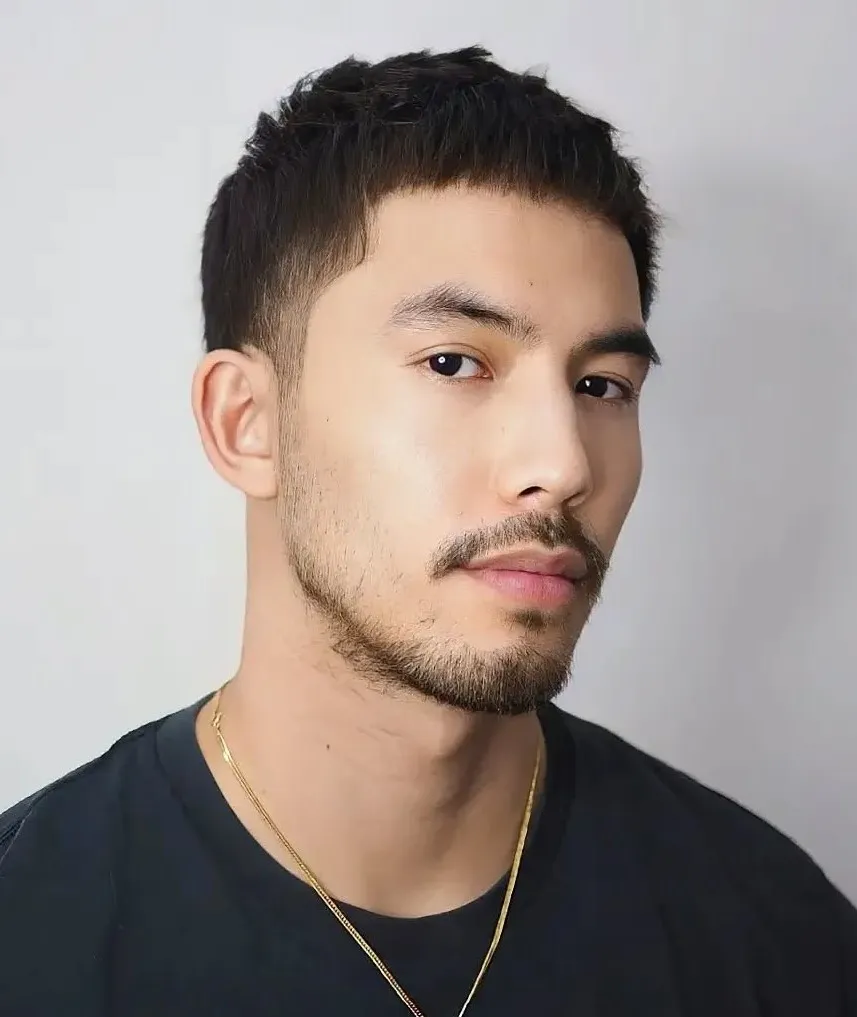 Buzz crop muška frizura koja naglašava simetriju i čiste linije ovalnog lica uz minimalističan, uredan izgled.