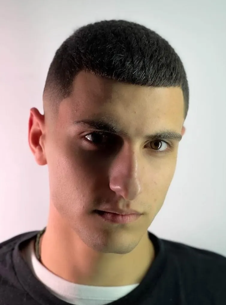 Buzz cut frizura koja naglašava simetrične i jake crte kvadratnog oblika lica.