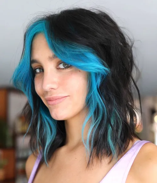 E-girl frizura s neonsko plavim pramenovima koji osvjetljuju lice i dodaju živahnost izgledu.