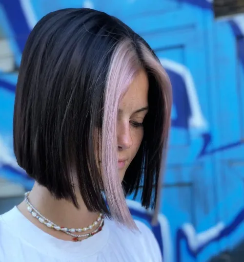 E-girl frizura sa sredinskim razdjeljkom i svijetlim pramenovima uz lice.