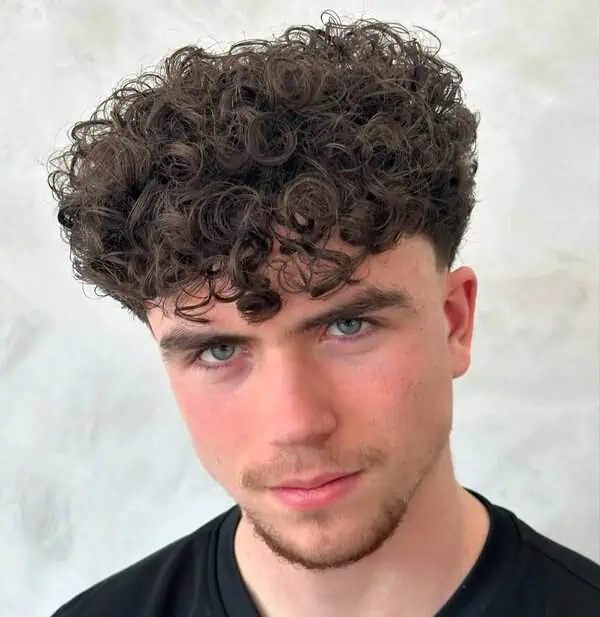 Kovrčava muška frizura koja dodaje volumen i omekšava linije srcolikog lica.