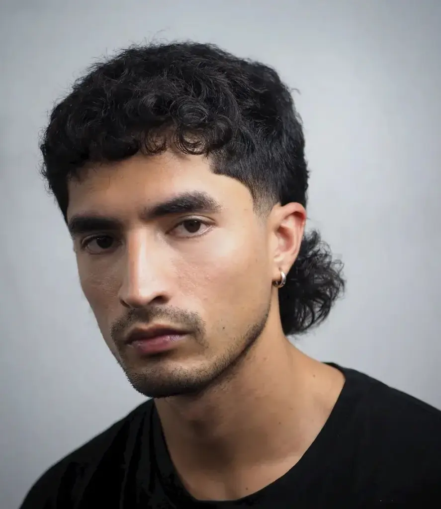 Kratki mullet koji dodaje teksturu i razbija stroge linije kvadratnog lica.