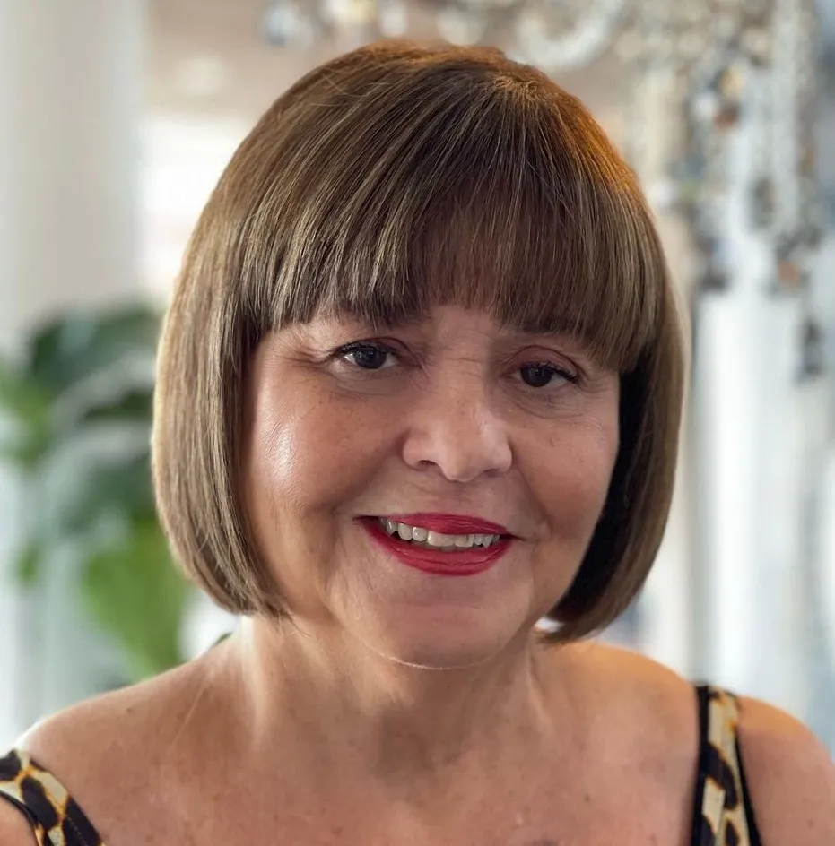 Kratki ravni rez s mekanom šiškom koja omekšava crte i uravnotežuje okruglo lice.