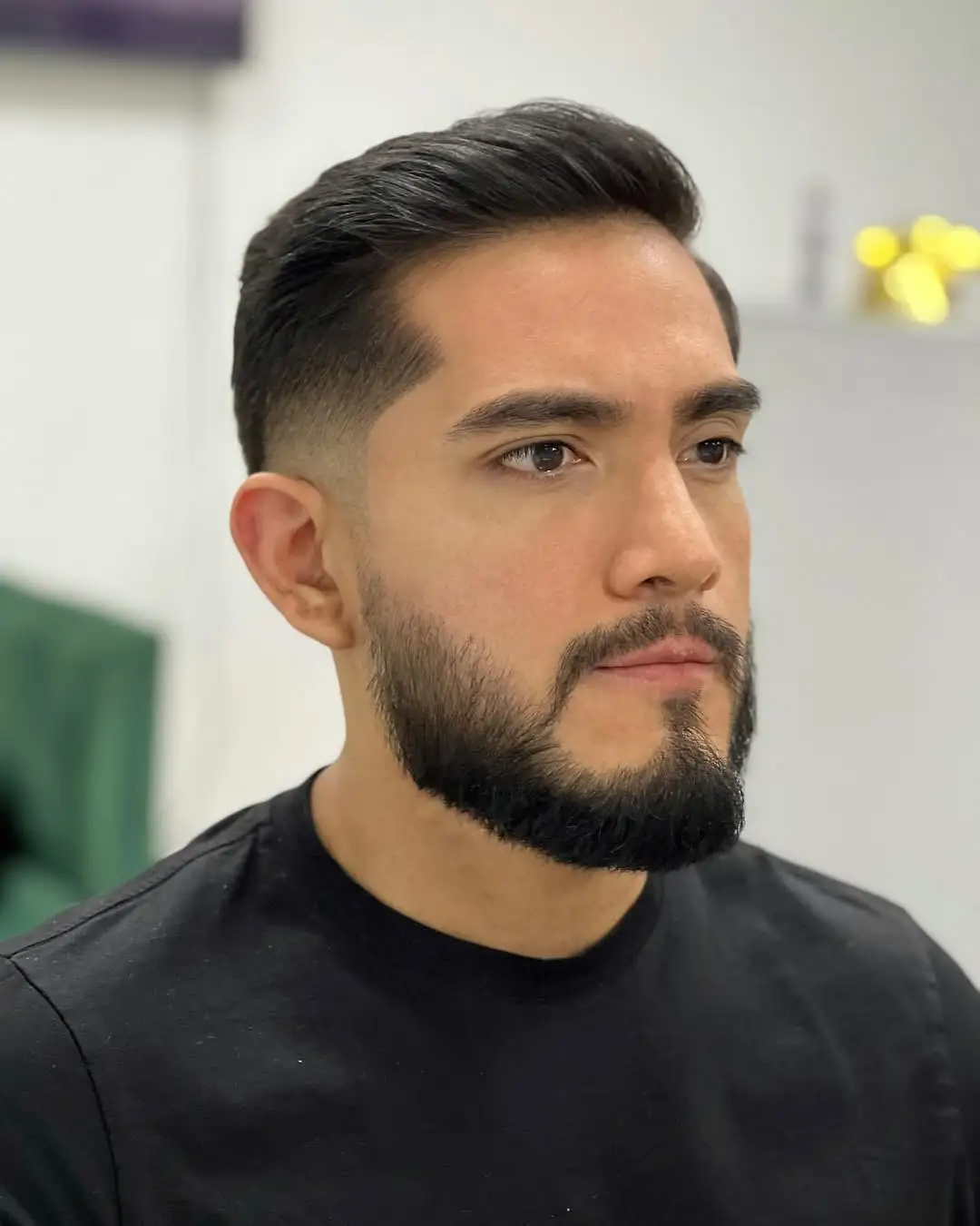 Low fade comb over frizura koja uravnotežuje dužinu i dodaje profinjen izgled duguljastom licu.