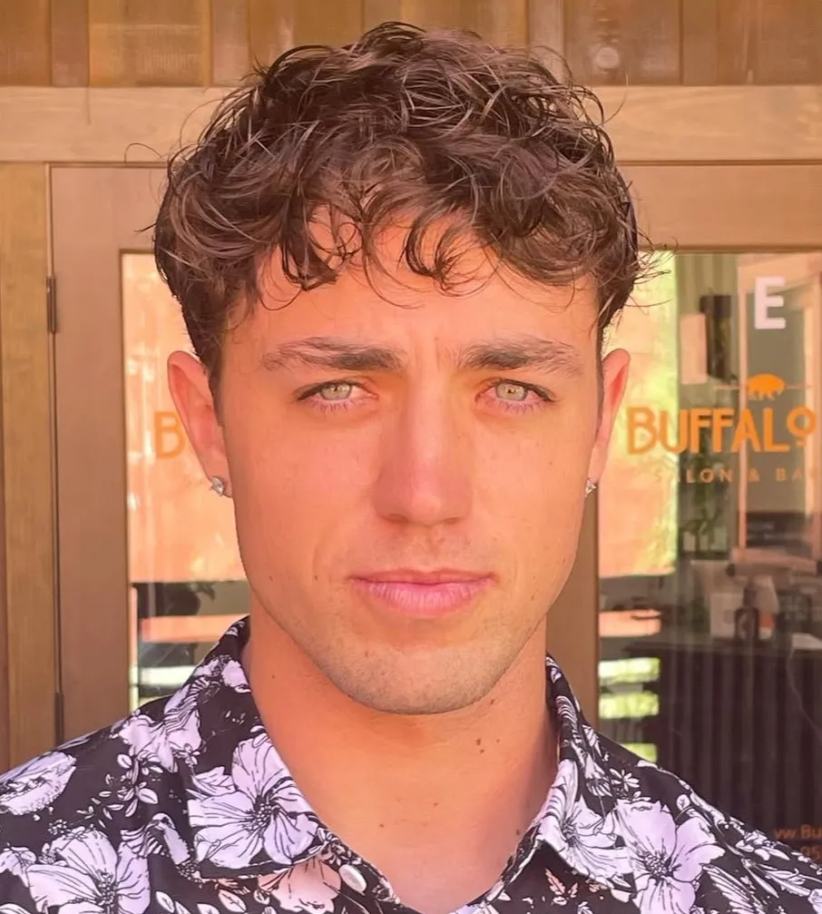 Muška frizura s mekim fade prijelazom koja uravnotežuje dužinu pravokutnog lica.