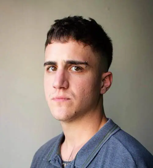 Kratka teksturirana muška frizura za visoko čelo koja dodaje volumen i smanjuje vidnu visinu čela.