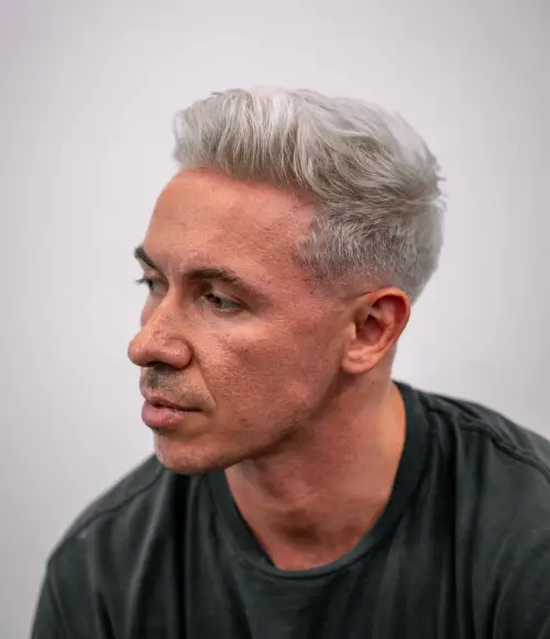 Sivi muški quiff koji kombinira volumen i teksturu za moderan zreo stil.