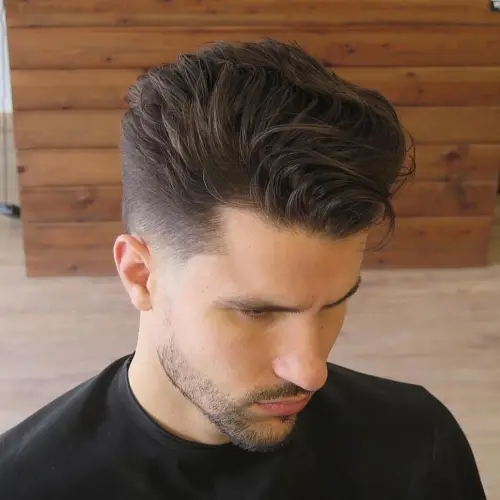 Kratki muški pompadour sa stiliziranim volumenom na vrhu i čistim fade prijelazom.