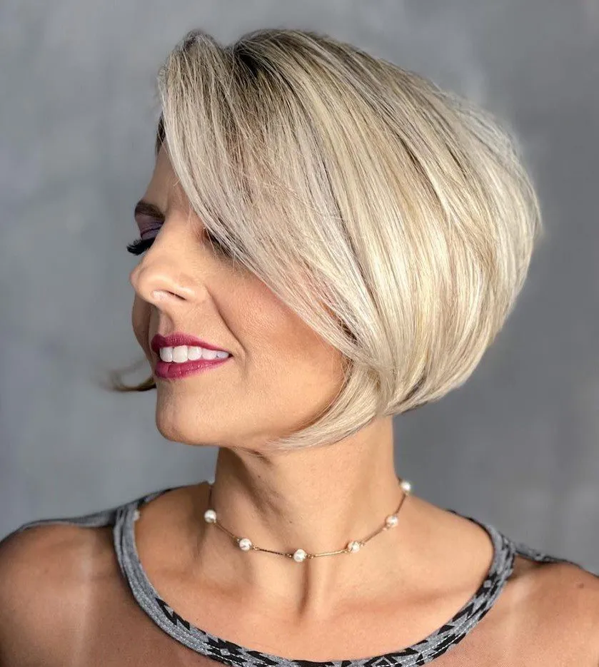 Paž do brade u svijetloj blond nijansi za starije žene, slojeviti kroj s volumenom.