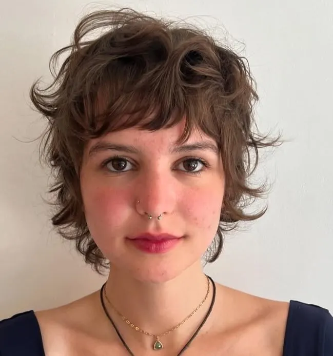 Pixie mullet frizura s razbarušenom teksturom i dužim slojevima na zatiljku za mekši izgled čeljusti.