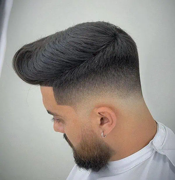 Pompadour drop fade frizura za muškarce s gustom kosom koja dodaje strukturu i elegantan volumen.