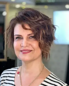 Razmršeni valoviti pixie bob koji omekšava kvadratno lice i dodaje lakoću i volumen.