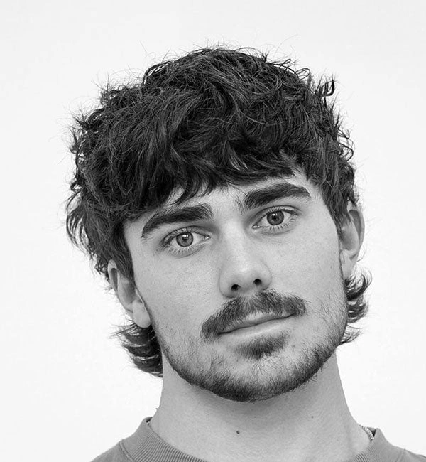 Razmršeni messy mullet s gustim šiškama i slojevitim stražnjim dijelom za moderan retro izgled.