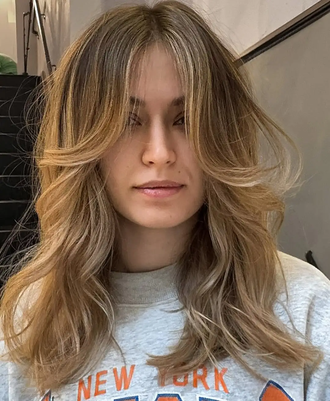 Srednje duga frizura s dugim šiškama koje omekšavaju crte i stvaraju romantičan izgled pravokutnog lica.