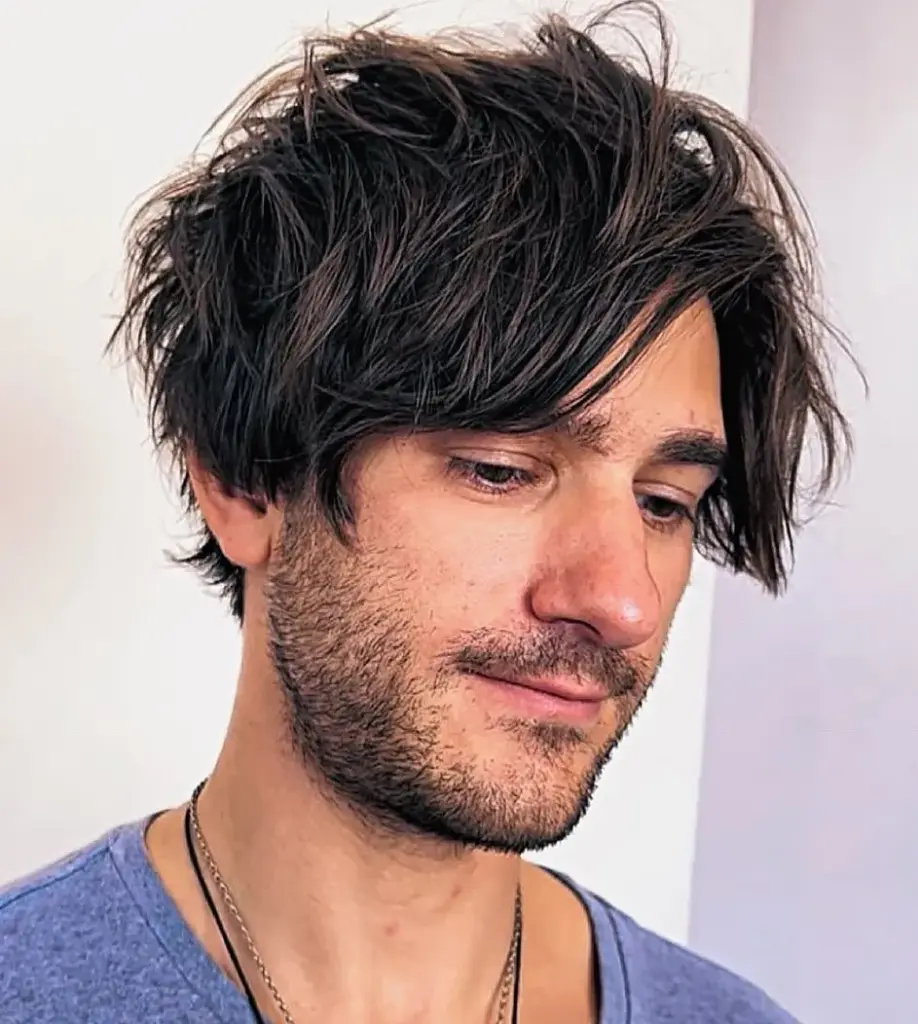 Srednje duga razbarušena frizura koja smanjuje vizualnu dužinu pravokutnog lica.