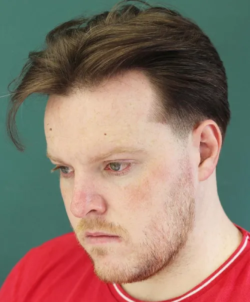 Elegantna muška frizura sa srednjim razdjeljkom koja vizualno izdužuje okruglo lice i stvara uravnotežen izgled.