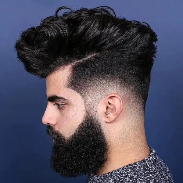 Taper fade frizura s dugim vrhom za gustu kosu koja kombinira urednost i volumen.