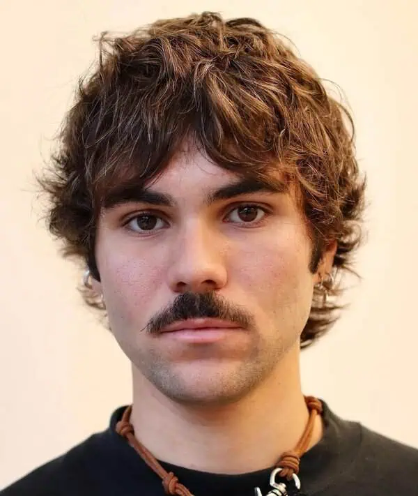 Textured shag muška frizura koja dodaje volumen i omekšava crte srcolikog lica prekrivanjem dijela čela.