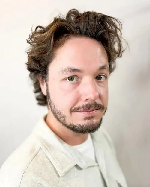 Valovita muška frizura koja omekšava snažne linije čeljusti kod kvadratnog lica.