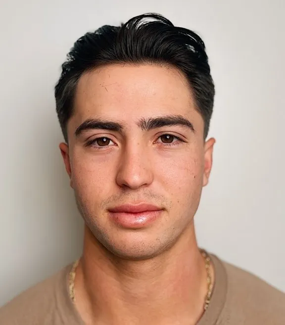 Zalizana frizura unazad koja naglašava uredan i simetričan izgled ovalnog lica.