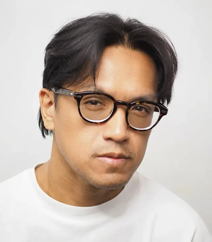 Muška zavesa frizura uz naočale koja omekšava crte ovalnog lica.