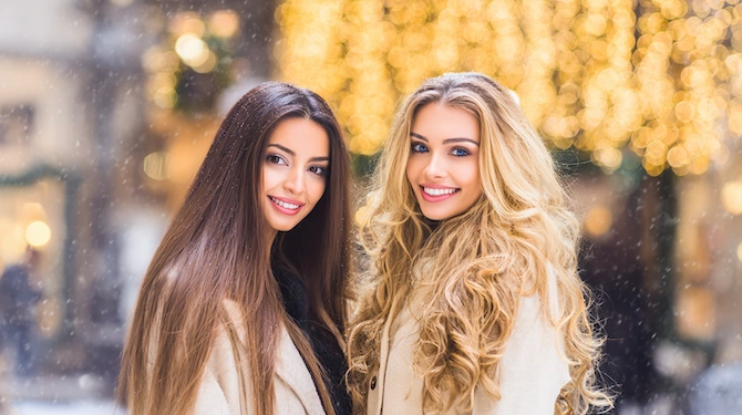 Duga ravna smeđa i valovita plava kosa u blagdanskom zimskom ambijentu.